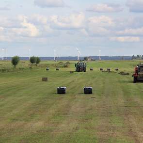 Bert Post, eigenaar van het loonwerkbedrijf aan de Meentweg in Eemnes heeft de grote balenpers zojuist afgekoppeld en gaat verder met de kleinere rode Kuhn die balen maakt van 80x70 centimeter.