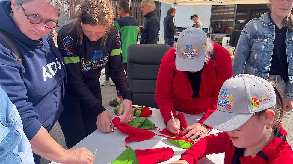 Deelnemers en supporters schrijven herdenkingsvlagjes die dinsdag mee naar de motivatiebijeenkomst gaan en woens- en donderdag bij het entertainmentpunt staan. Rood en groen zijn de BIG Challenge kleuren.